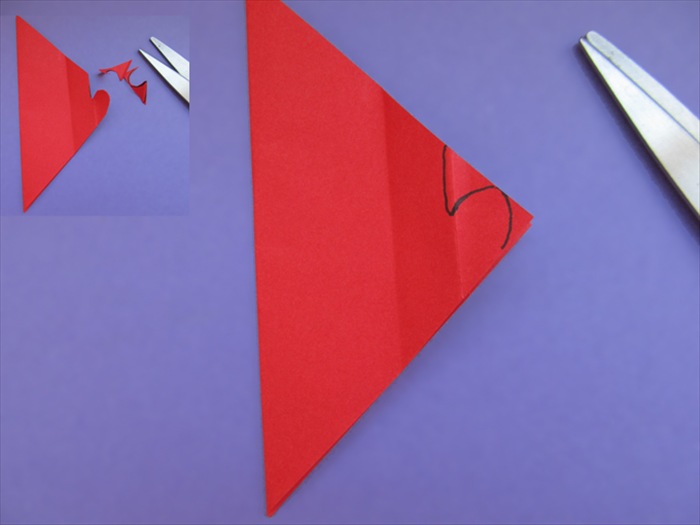 Cut out a half heart
When you get to the top of the heart,  cut a straight line up *a tiny bit to the left of the fold.
