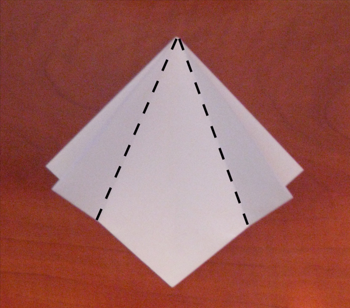 Make sure the open end of the paper is at the bottom.

Bring the 2 sides to the center crease and align the edges.
