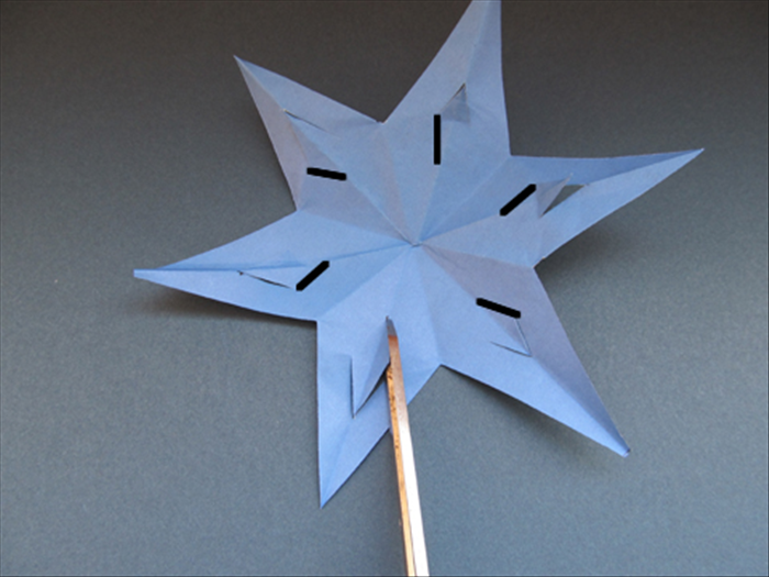 Unfold the star. Push the slits forward. 

Make a cut from the right edge to the center crease of each of the 6 slits. Do not cut the left side.
