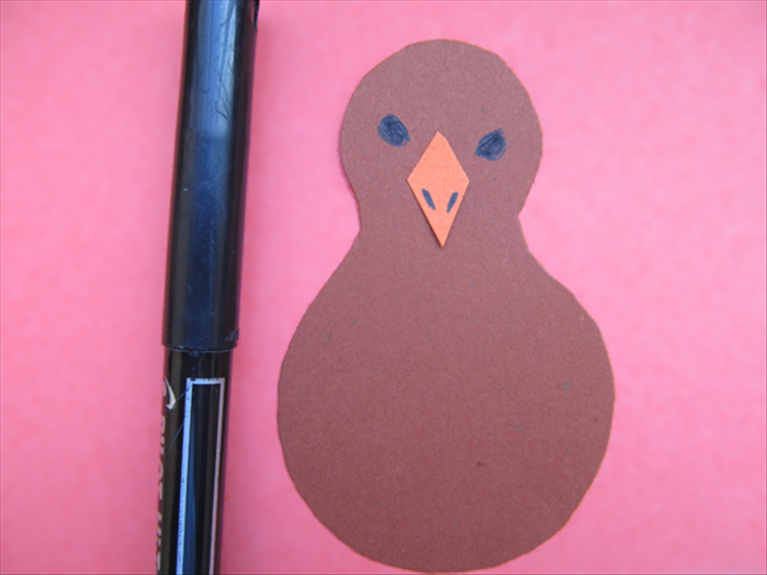 Draw or cut a piece of paper to make a kite or triangle shape for the beak.
Draw or cut paper eyes.
