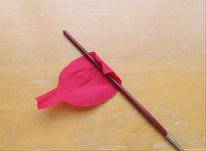 Roll the pointed end, with the paintbrush or skewer, to give it a curled end.
Repeat on all the petals except one. 

The petal that is not curled will be used for the center of the flower.
