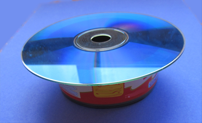 Place the CD on top of the open end of the tuna can