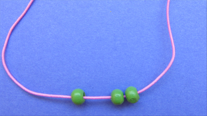 String 3 green beads to the middle of the string.