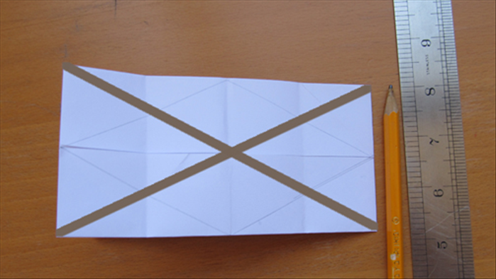 Draw 2 lines going across diagonally from the corners as shown
Flip the paper over to the other side and repeat steps12 To 14 on the back 
