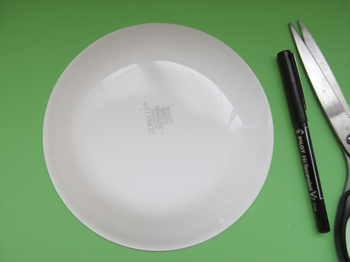 Trace the outline of a round object on a green piece of paper.
Cut out the circle