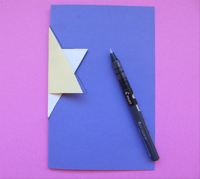 <p> Fold the 7 X 9 inch paper in half.  Insert the folded edge into the folded star.</p> 
<p> Trace the half star. You only need to trace it on the one side of the folded paper.</p>