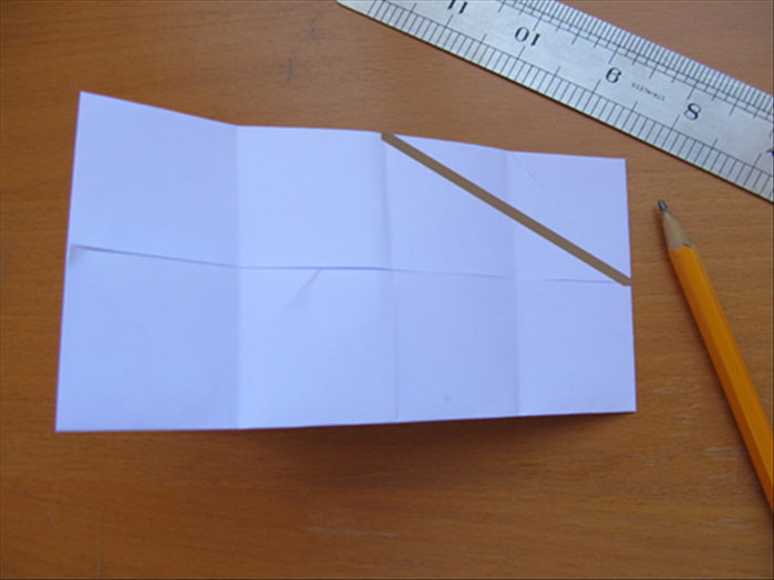 Fold the paper in half. There should be 8 squares and the flaps  facing inside
Draw a line from the center of the top to the center of the right side
