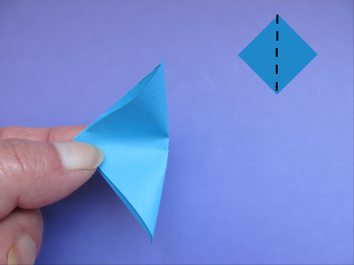 Hold a cut square diagonally
Bring the right point over to the left point and pinch it on the middle of the fold

