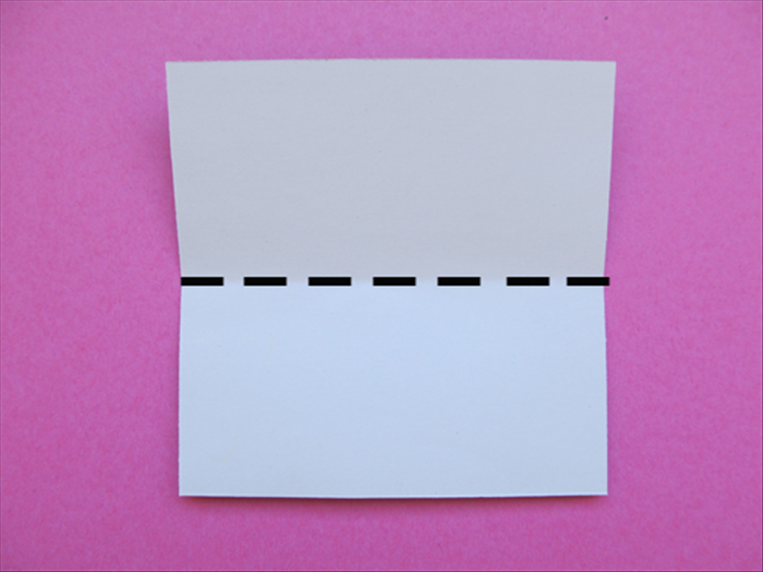 Hold the paper with the colored side facing down
Fold the top edge down to the bottom - to fold it in half.
