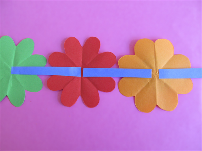 <p> Glue the strips along the crease in the back of the flowers</p>