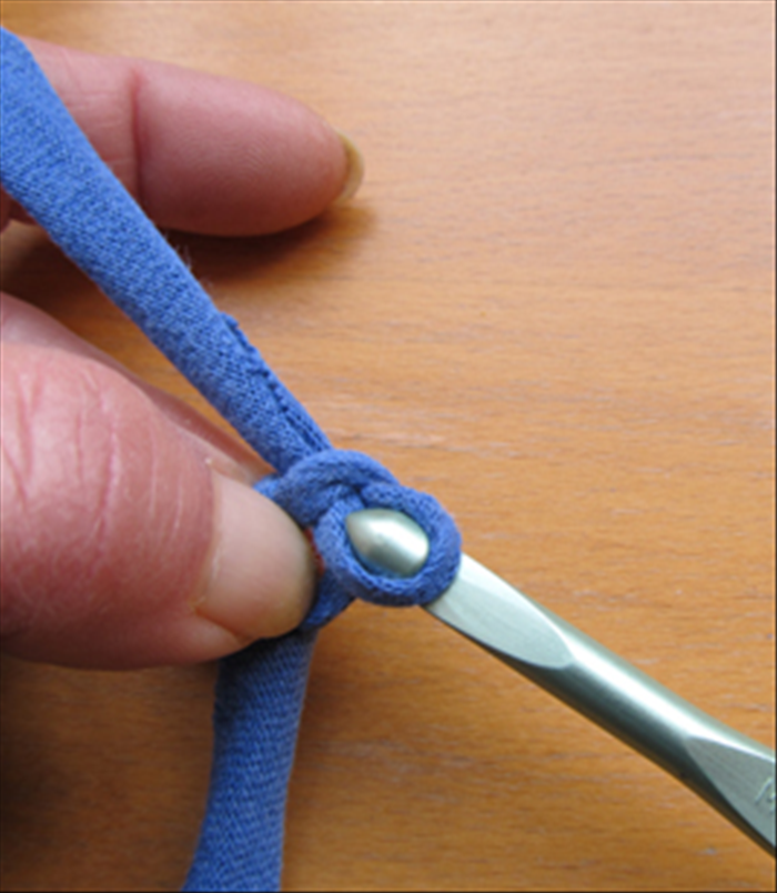 Pull the yarn through the loop of the knot.