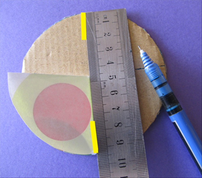 Align the straight edges of the quarter circle  with the pen marks and the edge of the cardboard circle
Make a  ¾ inch line on the top and bottom
