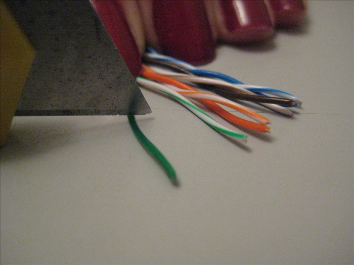 This next step needs to be done very carefully.

Inside of each colored casing is a copper wire. You need to cut off enough of the casing to get to about an inch and a half of the copper wire.

It can be done with a wire cutter by making a cut around the casing. If you can do that without cutting the copper wire inside also.. great! 

A lot of people find it hard not to cut the copper wire that way and an other option is to use the utility knife to  make a slit  1 1/2 inches from the end and again on the back side. 

