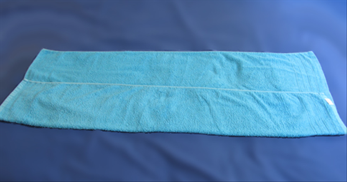 If you want to make a shorter roll, fold the towel in thirds lengthwise
Fold a long edge 1/3 of the way.
And fold the opposite long edge  over it to the other side

