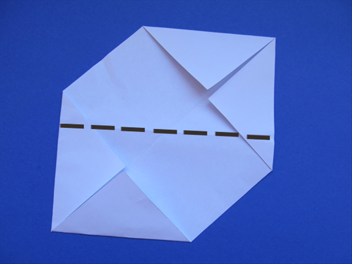 Rotate the paper so that the folded points are at top and bottom as shown in the picture

Fold it in half by bringing the bottom straight edge up to align with the top straight edge
