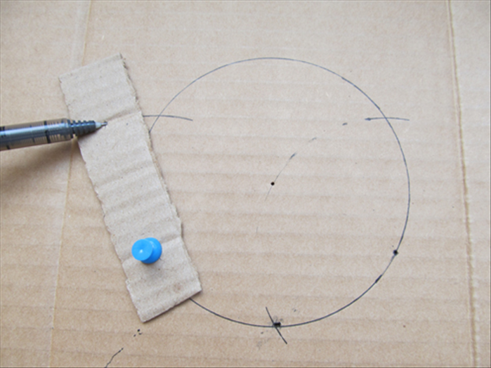 Put a pin through a hole on the strip and the hole you just made in the cardboard
Put the pen point in the second hole, rotate the strip and mark where it comes to the circle.
