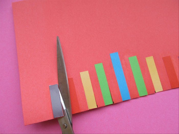 Cut slits, up to the top on both sides of each of the colored papers.