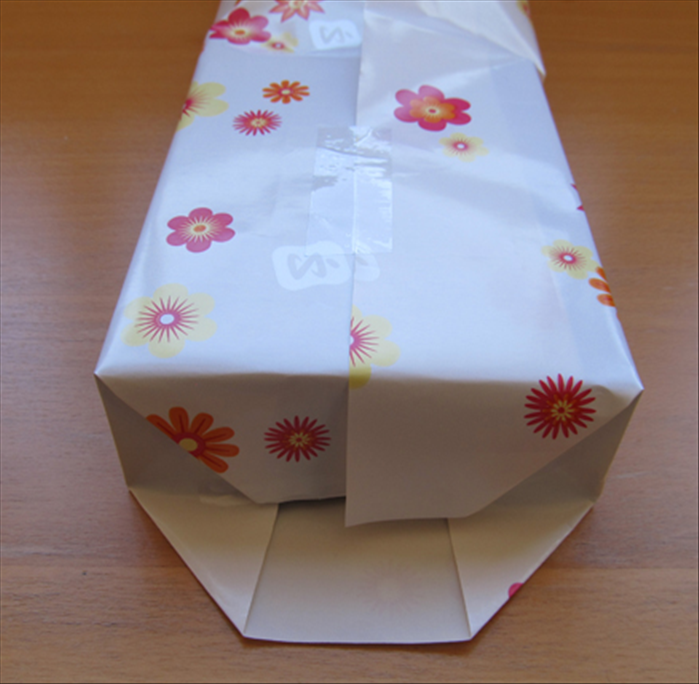 Push down the paper along the top edge of the gift.