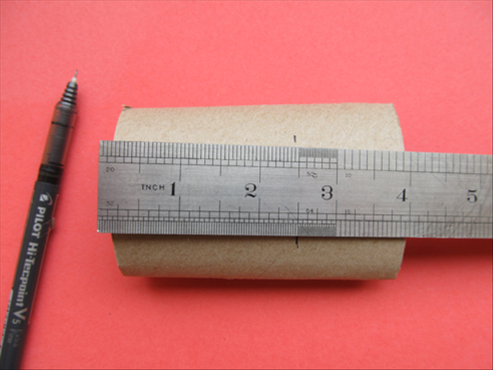 Squash the toilet paper roll.
Measure and mark 2 ½ inches a few times.