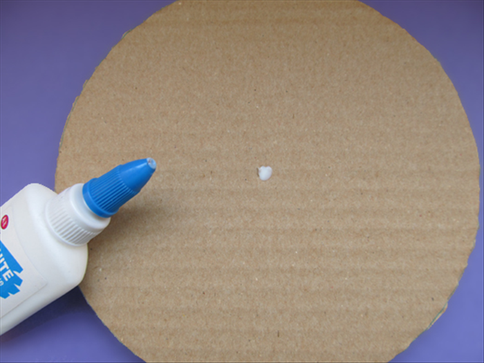<p> Put glue in the hole of the 5 large circles that you glued together.</p>