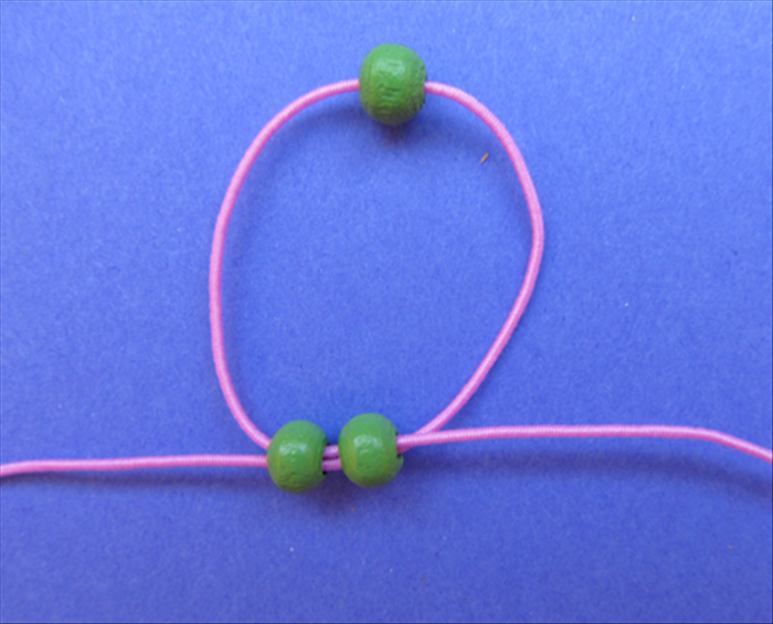 Result. 
Pull the ends of the strings until the 2 beads are pushed up against the single bead.
