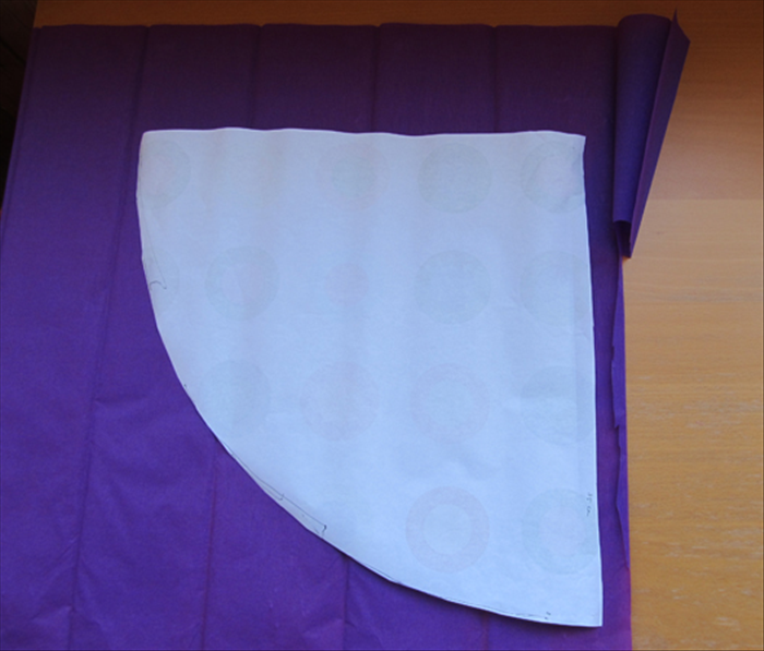 If you are using decorative paper skip to step 6.


Put glue around the edges of the paper and glue it to the crepe paper or fabric.

If you are using fabric use glue that adheres to fabric
.
Cut along one straight edge and the arc.
Leave a little extra along the other straight edge so you can fold over it.
