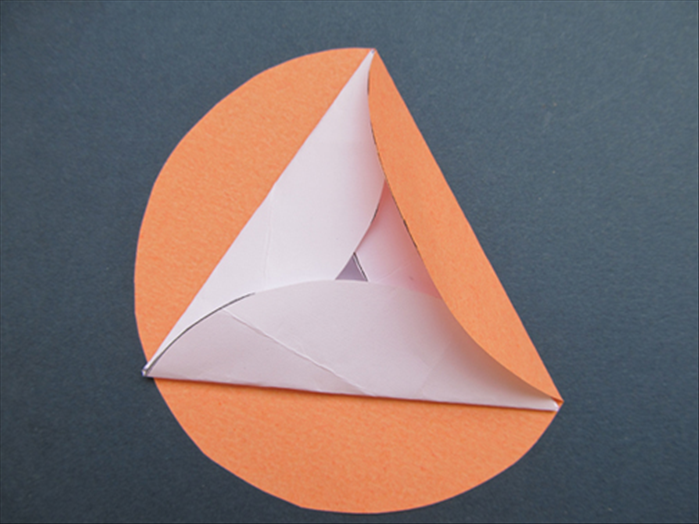 Fold one side up over the edge of the triangle