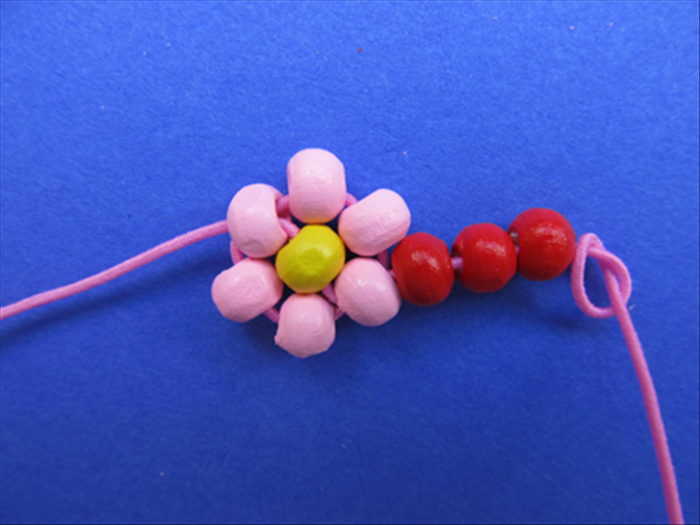 Push the center bead into place between the petals and pull the thread to tighten