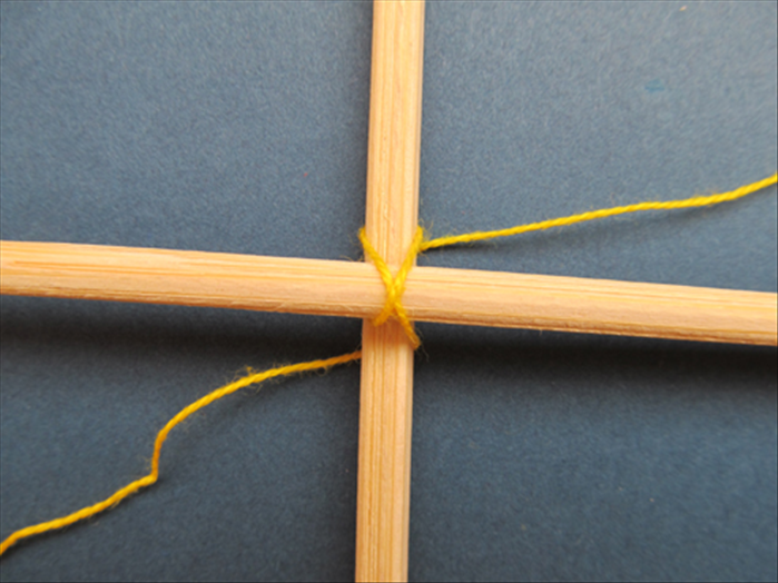 Wrap the string behind the left side and up behind the top to form an X