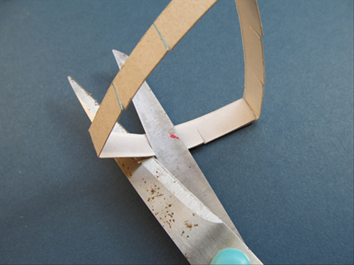 Use the present cuts as a guide.Cut again to make a cut on the overlapping cardboard.