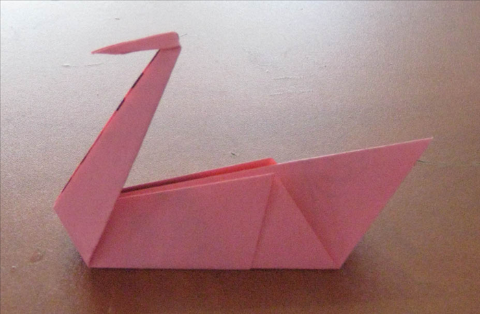 Lift the beak and  squash in place.

Your origami swan is finished.