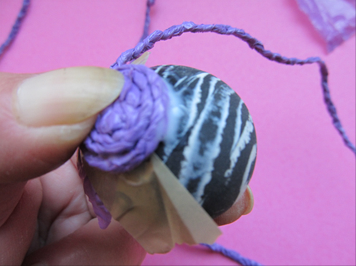 Add more glue and continue winding the braid.
Do only a few rounds at a time. 
Hold it in place with the rubber band until the glue dries completely.
