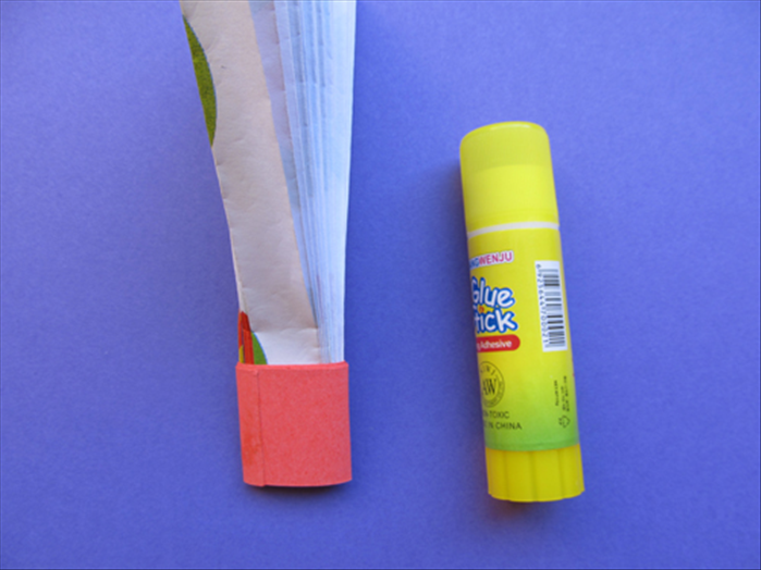 Wrap the strip around the bottom of the folded paper and glue the end closed