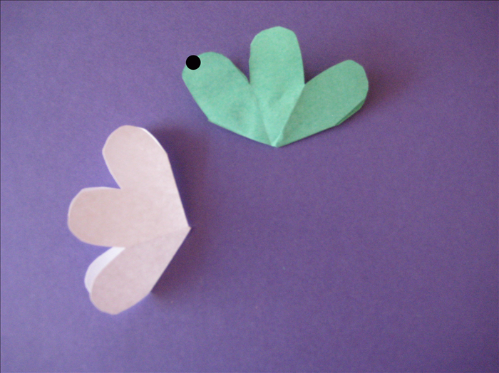 Now we are going to glue the flowers together . 
It is important that you only put a dot of glue on the tip  – do not glue more than the tips.

Take one flower and put a dot of glue on the tip of  left petal.
