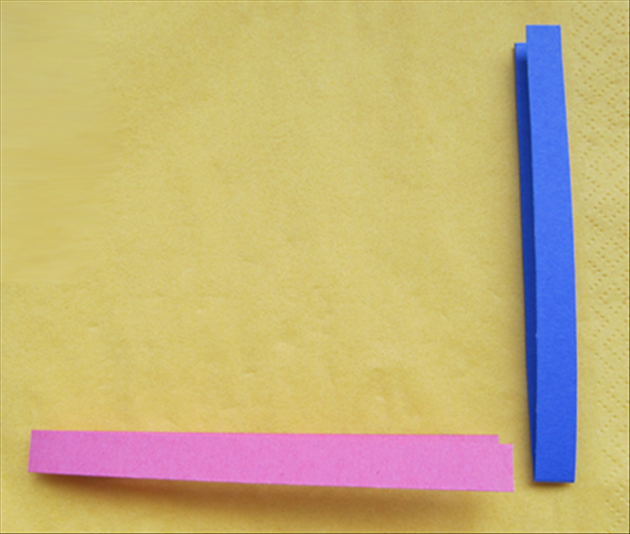 Fold the 2 strips in half.
Place one horizontally with opening on the right.
Place the second strip vertically with opening at the top.

Insert the bottom layer of the horizontal strip between the layers of the vertical strip
and slide it all the way in
