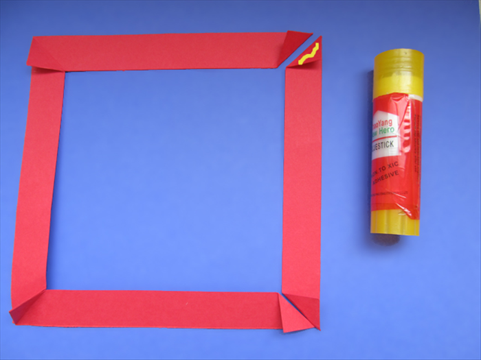 <p> Take the last strip and put glue on the top triangle.</p> 
<p> Align the edges of the triangle next to it and press them together.</p>  
<p> Before the glue dries flip the frame over to check if they are aligned on the other side.</p>  
<p>  </p>