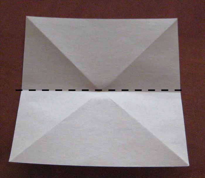 Flip the paper over to the back side.

Place the paper with the straight edges on the top, bottom and sides.
Fold in half horizontally and unfold.