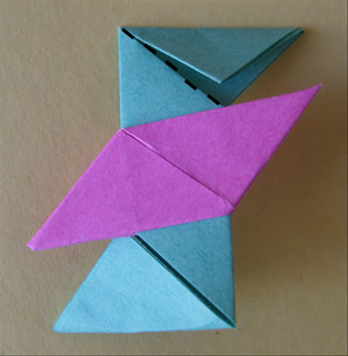 <p> Flip the paper over to the back side. Fold the top down along the flap.</p>