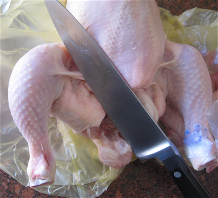 Next cut both legs
Put the chicken on its back
Pull a leg outwards and cut the skin between the leg and the body
