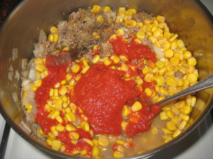 Add the salt and pepper, soy sauce, tomato paste and corn- that includes the liquid from the corn can
Mix well  
