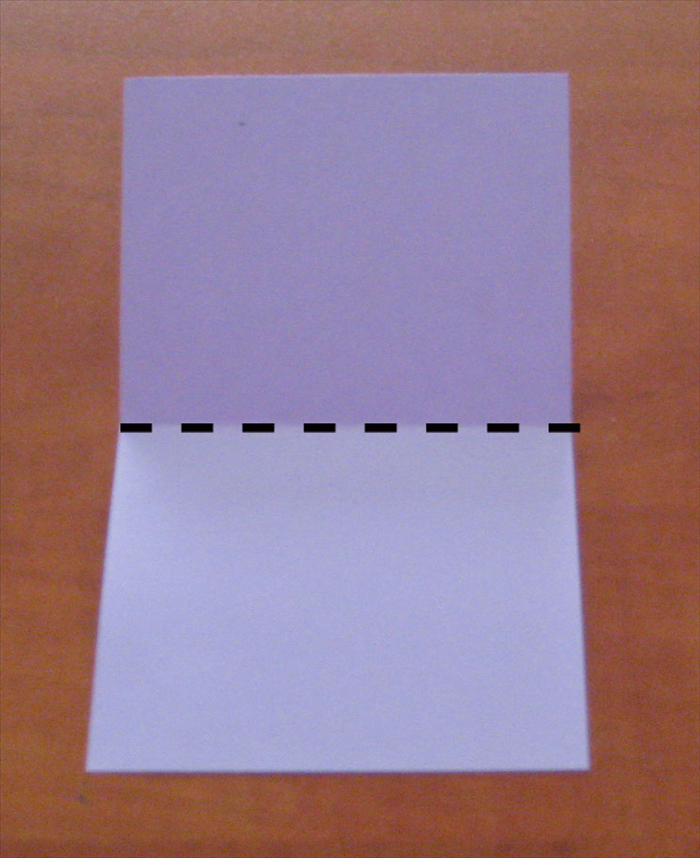 Place the paper with the short ends at the top and bottom.
Bring the top edge down to the bottom to fold in half.