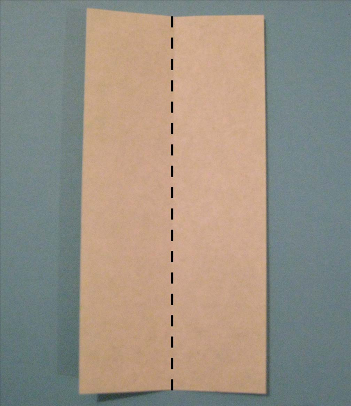 Place the paper with the colored side facing down and the short ends on the top and bottom.

Fold it in half lengthwise.
Unfold
