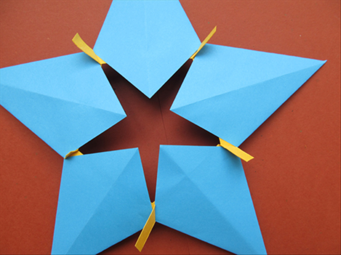 Flip the star over to the back.
You can fold the strips sticking out along the edge of the kite shape or….
