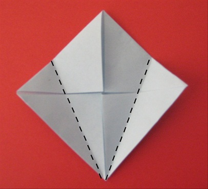 Fold the left and right points towards the center and align the edges with the center crease