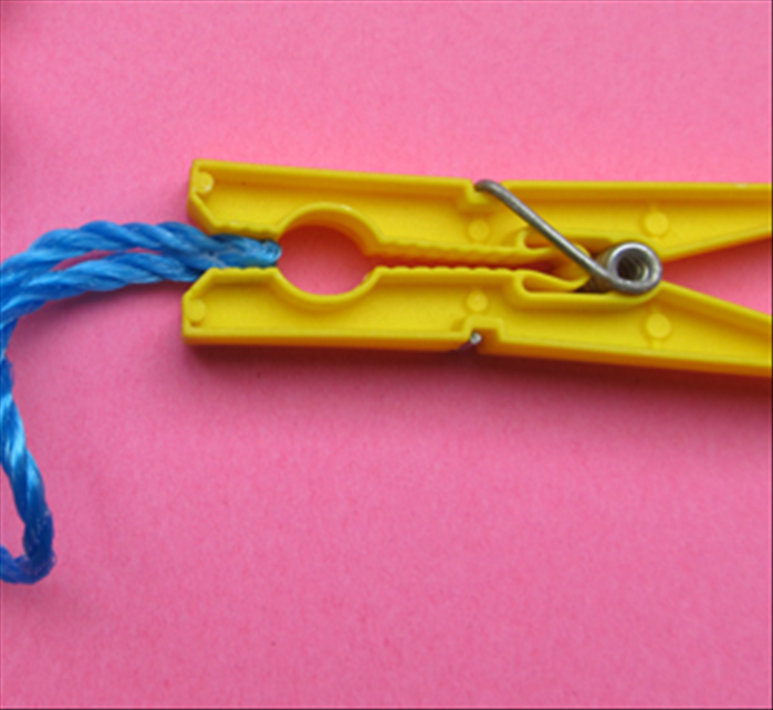 Fold the end of the plastic cord and glue it together. Hold it in place with a clothspin until the glue has dried completely.