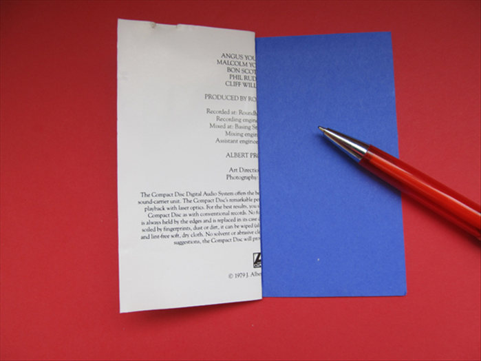 Align the folded paper to your background paper and use the edge to make a straight line.