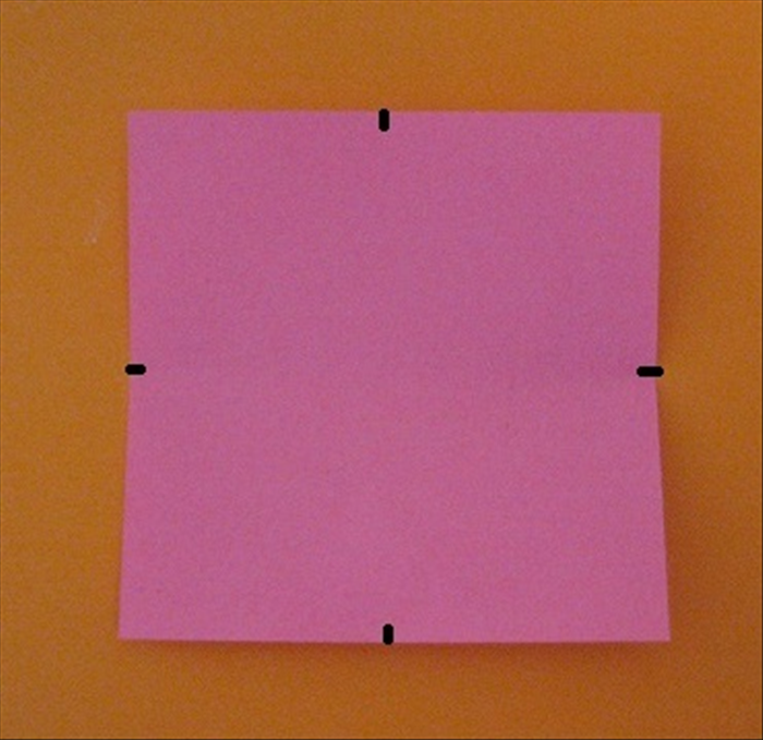 Fold the paper in half each way. Do not crease, only pinch to mark the centers of the sides.