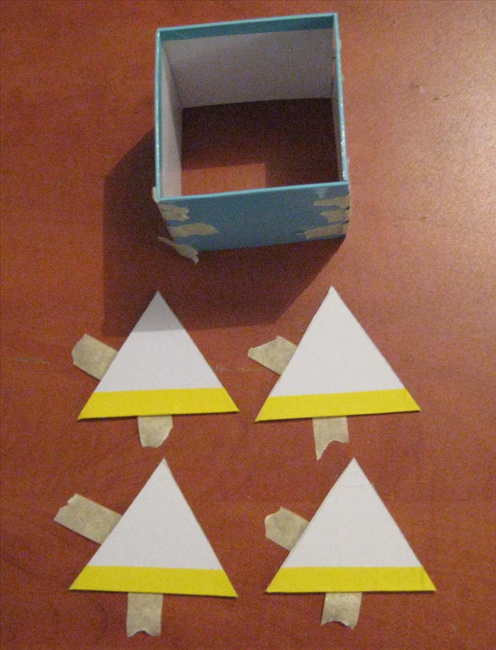 Put tape, with the sticky side up, on the left side and 
bottom of each triangle.

Put glue on the right side of each triangle.

Put glue on the top edge of the square base you created before
