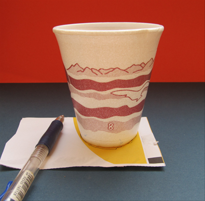 Trace the bottom of the paper cup on scrap paper.
A piece of junk mail with a pretty yellow was used in this guide

