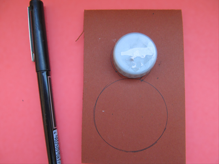 Center a bottle cap or similar small round object at the top of the circle you made in the last step.
Trace the bottle cap
